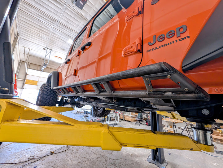 Orange Jeep Gladiator (JT) with Trailbreaker Series rock sliders installed